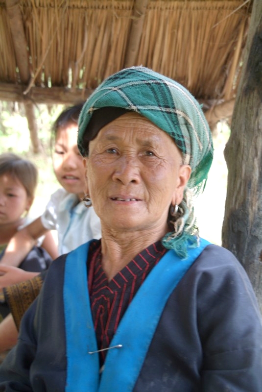 Laos: Alte Frau hütet die Kinder